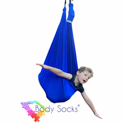 Child in a blue Lycra Therapy Swing with arms outstretched.