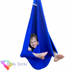 Child in a blue Lycra Therapy Swing with feet and face showing.