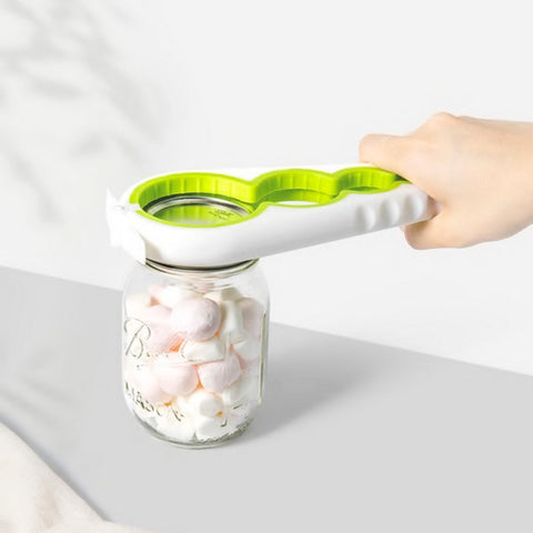 A hand grasping the 5-in-1 jar opener wrapped around the lid of a jar full of marshmallows