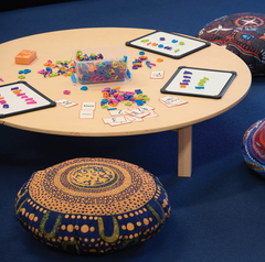 First Nations Round Cushions Set of 4 featuring authentic Indigenous artwork placed around a low table