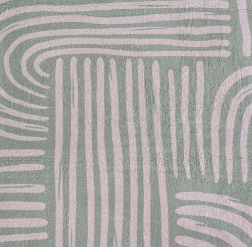 Close up of the pattern on the Arcade Designer Print soft touch mat of white curves and lines on pistachio green background