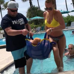 Two people carrying a person out of a pool using the Perfect Lift