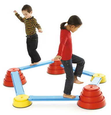 Two children walking on the Build N’ Balance Course modular balance set with tops and reinforced planks for gross motor development, coordination, therapy and school movement activities