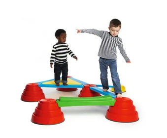 Two children using the Build n’ Balance Platform Kit modular balance course set with raised stepping tops, connecting planks, platform, and rocking plank for gross motor development, balance and coordination activities
