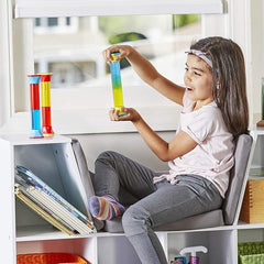 Young girl at table holding a shaken Calming Gel Tube