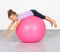 Child using pink Swiss Spike Ball for balance, coordination and gross motor movement activity