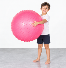 pink textured exercise ball held by child for balance and gross motor activities