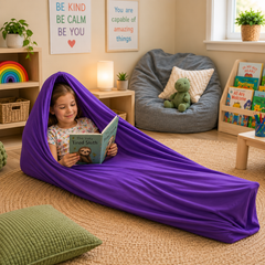 Child sitting inside a movement tube, reading a book