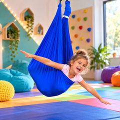 Child using Blue Therapy Swing with arms outstretched.