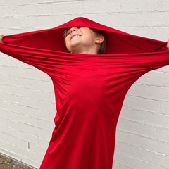 A child stretches out in a bright red movement tube.