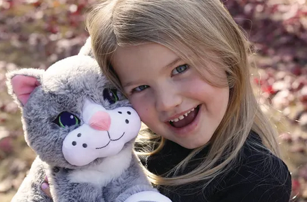 Close up of Chloé the Comfort Cat weighted sensory companion with textured surfaces and lavender hot and cold pouch held by young girl