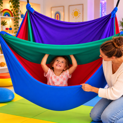 A child enjoys the interior of a layered lycra therapy swing with her mother