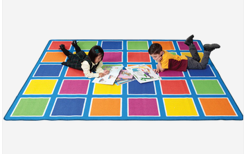 Young boy and girl relaxing on the Colour Placement Rug with 30 bright squares in a 4m x 3m classroom seating layout