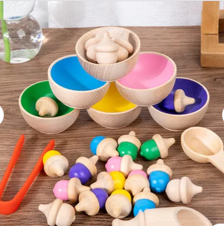 Colour Sorting Set with small wooden bowls, scoops, tweezers, and acorns coloured green, yellow, pink, purple, blue, and natural wood.
