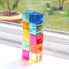 Colourful gem cubes stacked on a windowsill.
