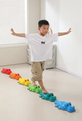 Young boy balancing on a line of Crocodile Balance Stonest with six colourful non-slip stepping stones for indoor balance, gross motor development, sensory play and obstacle course activities
