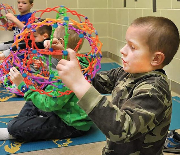 This is an image of some children using the Hoberman Sphere.