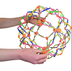 This is an image of someone holding an open Hoberman Sphere .