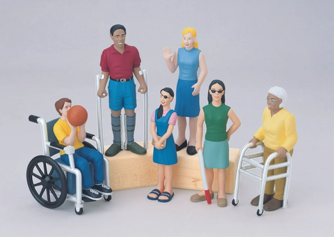 Set of toy figures depicting people with disabilities on a plain background