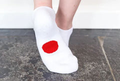 Legs of child wearing white Dot On A Sock ankle socks with red dot