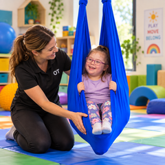 Child using Lycra therapy swing with help from a therapist adult