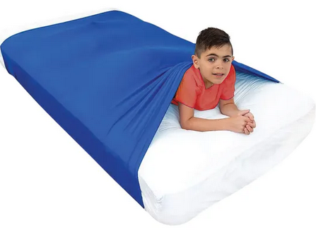 Young boy using the navy blue Elizabeth Richards compression sheet for calming sensory input, emotional regulation, autism support, ADHD, classrooms, and sleep routines