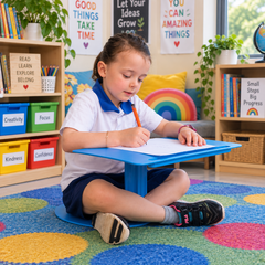 Primary school student using blue Flexi Desk portable learning desk for writing activity