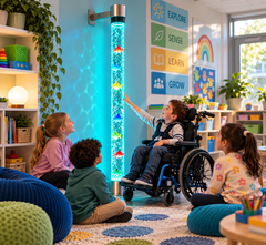 Children sitting around a bubble tube on the floor with a child in a wheelchair.