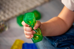Child squeezing a green Jelly Blox 