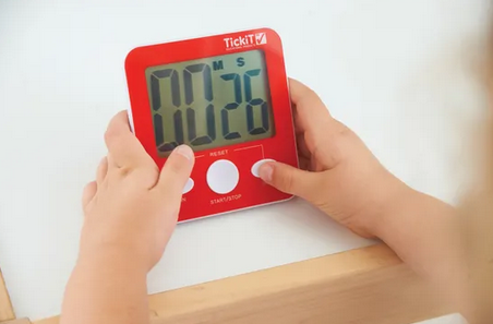 Child's hands holding Jumbo Timer in red colour with big LCD display
