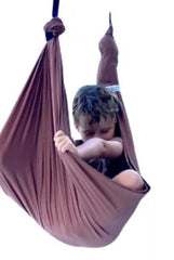 A child sits in a brown, two-layer lycra swing set against a plain white background.