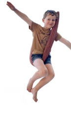 A child relaxes in a brown, double-layer lycra swing, arms stretched wide, against a simple white background.