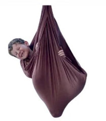 A child sits in a brown, two-layer lycra swing set against a plain white background.