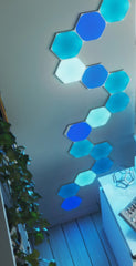 Nanoleaf hexagon shapes glowing blue wind their way up the wall like a snake.