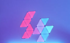 Nanoleaf 15-pack interactive lights on the wall lit up in purple and blue.