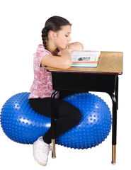 Girl at a desk sitting on the Inflatable Sensory Ball with Tactile Nubs peanut-shaped balance ball for flexible seating, occupational therapy, physiotherapy, classroom learning, NDIS support and core strength development.