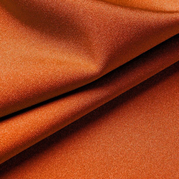 Close-up of orange lycra fabric with folds