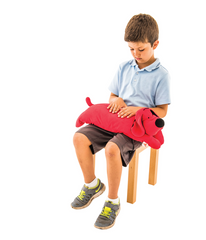 Young boy on chair with Training2s Patrick the Dog Calming Weighted Lap Pad on his lap.
