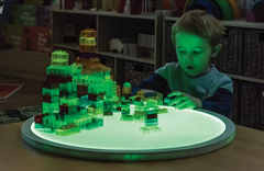 Round Colour Changing Light Panel 60cm turned on with green light and little boy building translucent colour blocks on it