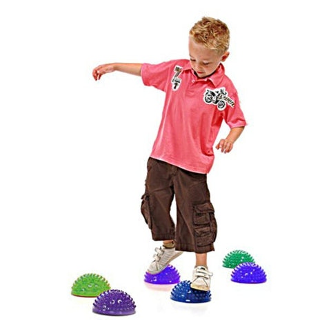 This is an image of a boy balancing and walking on the Spikey Sensory Stepping Stones - Accupressure Walk Pods (set of 6)