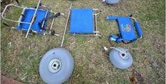 This is an image of the Sandcruiser® All Terrain Chair – Beach Wheelchair taken apart and laying on the grass.