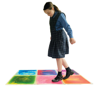Young student walking on the Elizabeth Richards Sensory Liquid Floor Tiles Pack of 6 used in a sensory room for interactive sensory play and calming movement activities