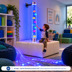 A child sits on a podium, touching a bubble tube filled with fish, while fiber optic lighting glows on the floor.