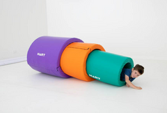 This is an image of 3 tunnels - stack - A tubes. colours are large purple on the outside, orange in the middle and green in the centre. There a young child crawling out of the green tunnel.