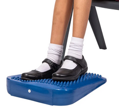 Student sitting on a chair using the Tactile Foot and Support Wedge for comfort and focus.