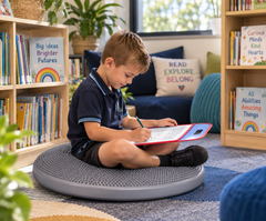 Child using a large tactile cushion for focused learning in a quiet school library