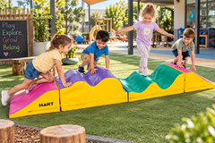 Children using a Sensory Tactile Rollercoaster foam obstacle course in a preschool playground.