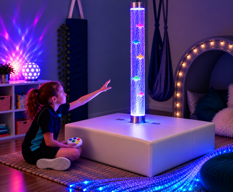 A child reaching out to a bubble tube on a white podium while holding a wireless controller.