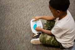 Boy holding the white and blue coloured Time Timer Original 20 Minutes visual countdown timer with disappearing coloured disk for classroom focus, transitions and time management
