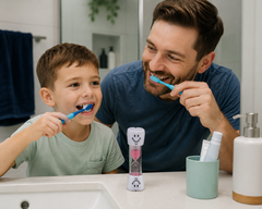 Father and son brushing their teeth using a 2-minute tooth sand timer.